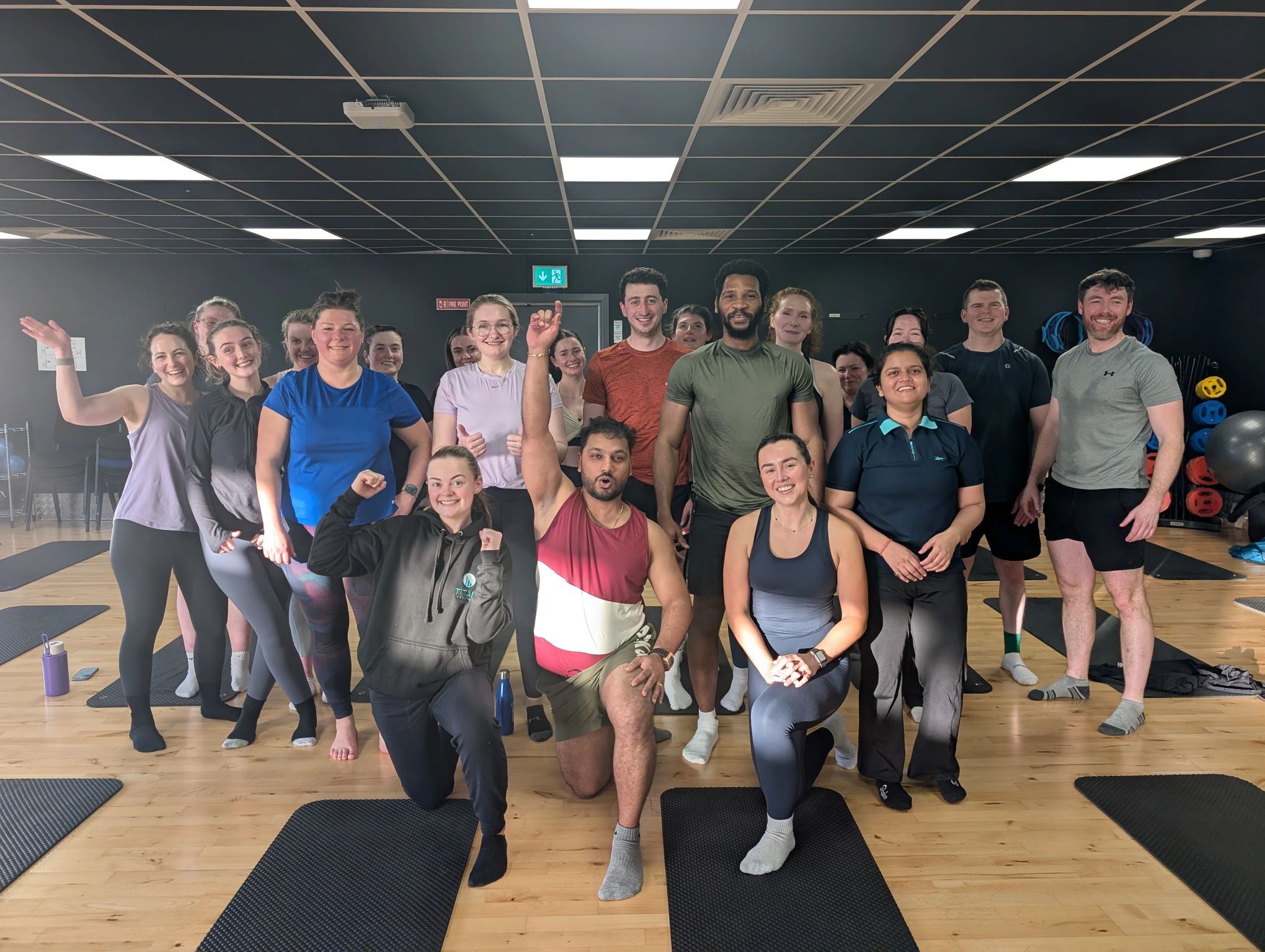 A group of employees and instructors posing together after a fitness class in the on-site gym